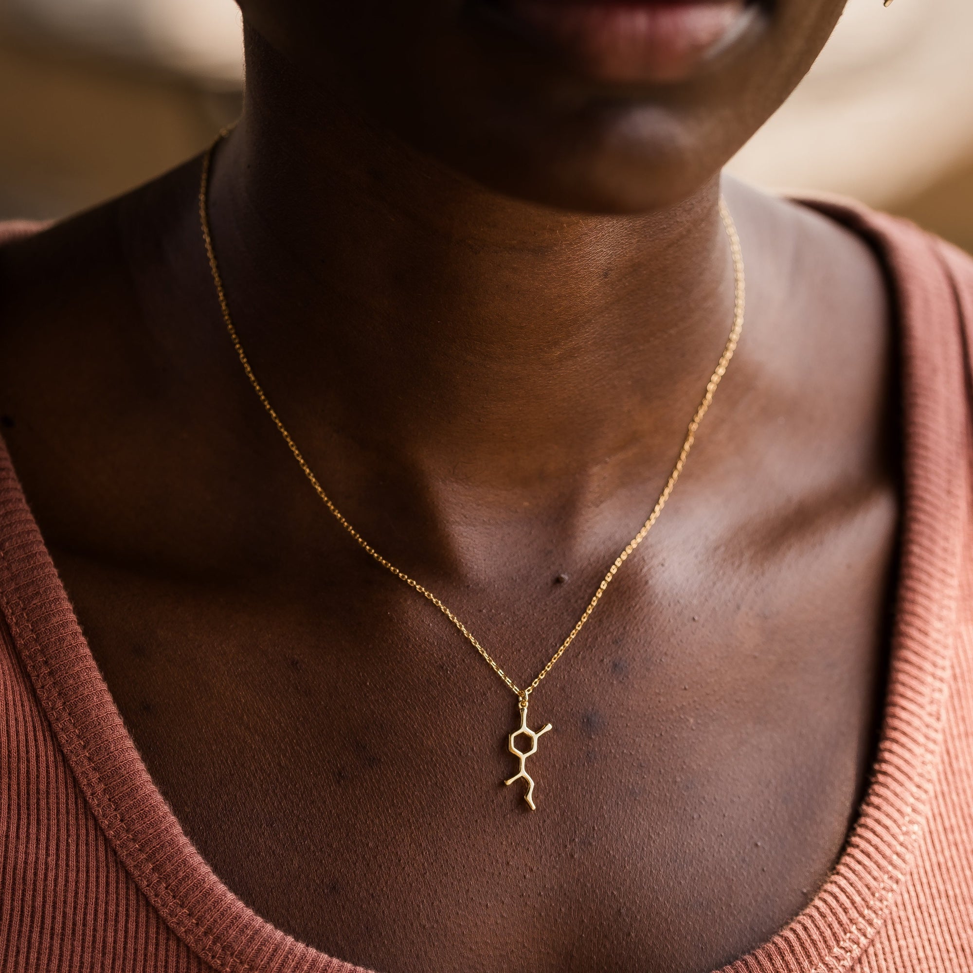 Model wearing adrenaline molecule necklace in gold - chemistry inspired jewellery for science lovers | My Chemical Gift