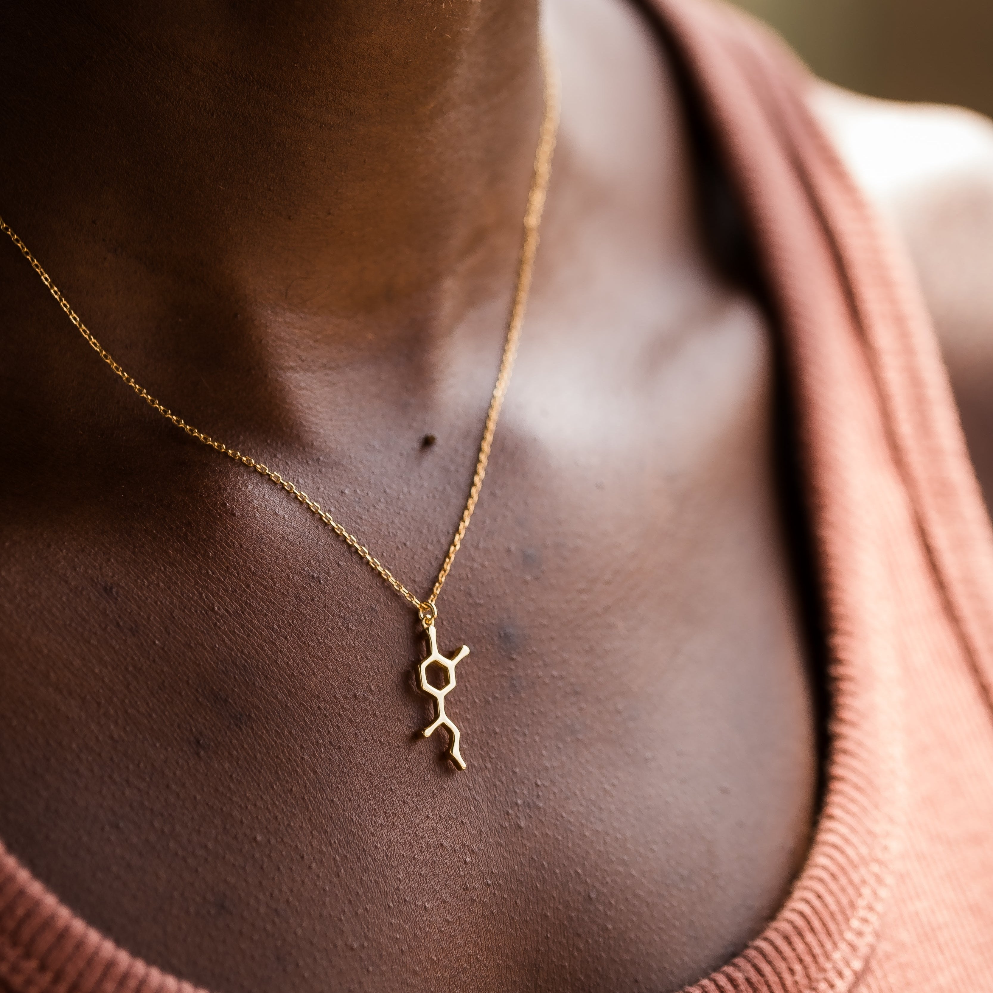 Model wearing adrenaline molecule necklace in gold - chemistry inspired jewellery for science lovers | My Chemical Gift