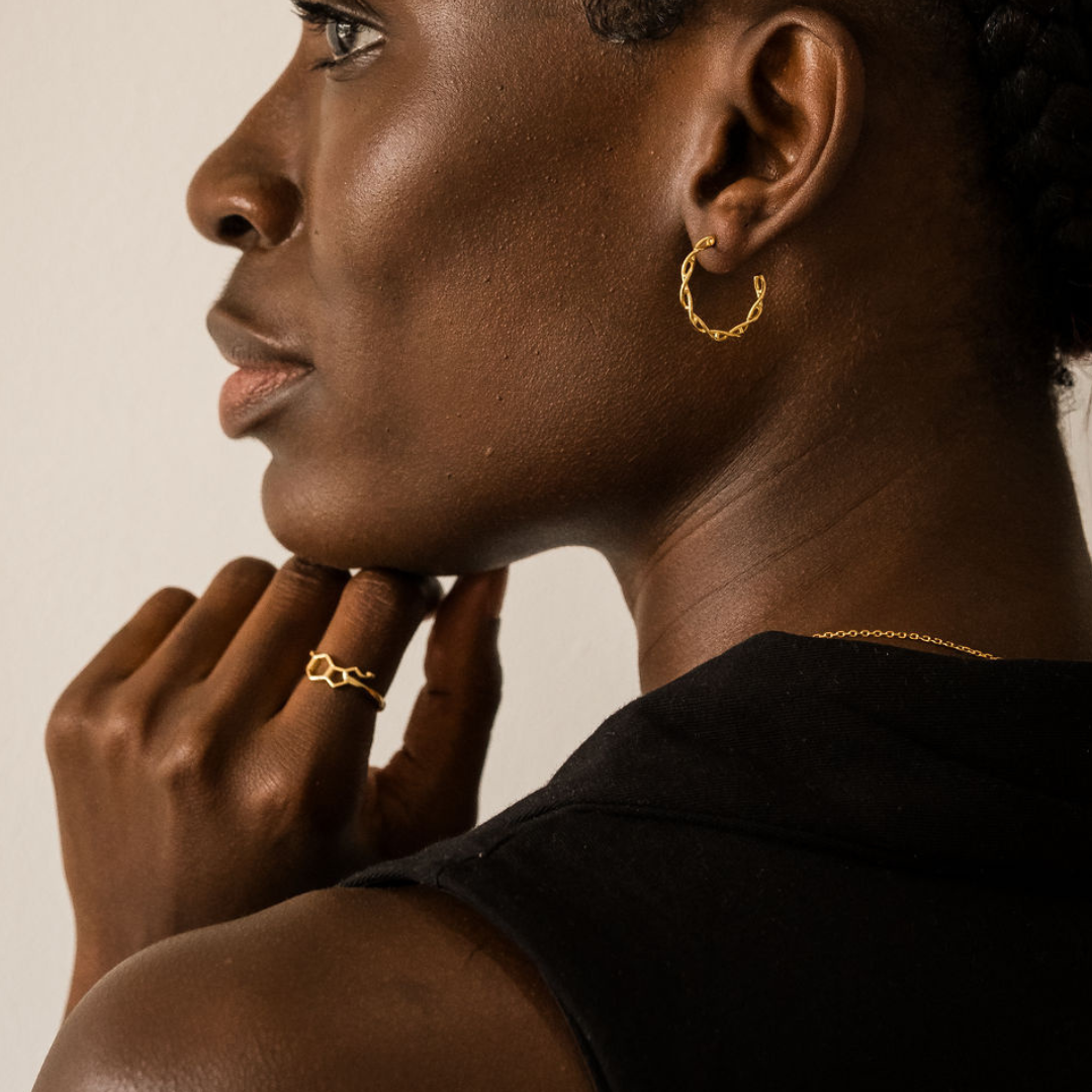 Model wearing DNA double helix hoop earrings and serotonin molecule ring in gold - chemistry inspired jewellery for science lovers | My Chemical Gift