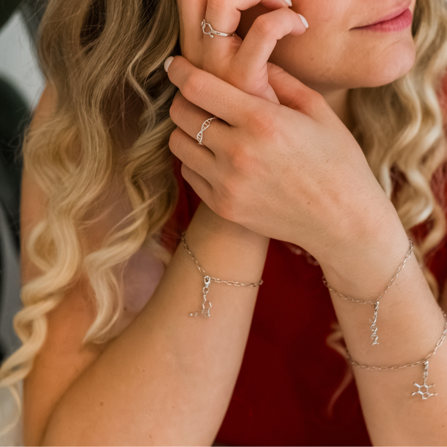 Model wearing serotonin molecule silver charm bracelet - chemistry inspired jewellery for science lovers | My Chemical Gift