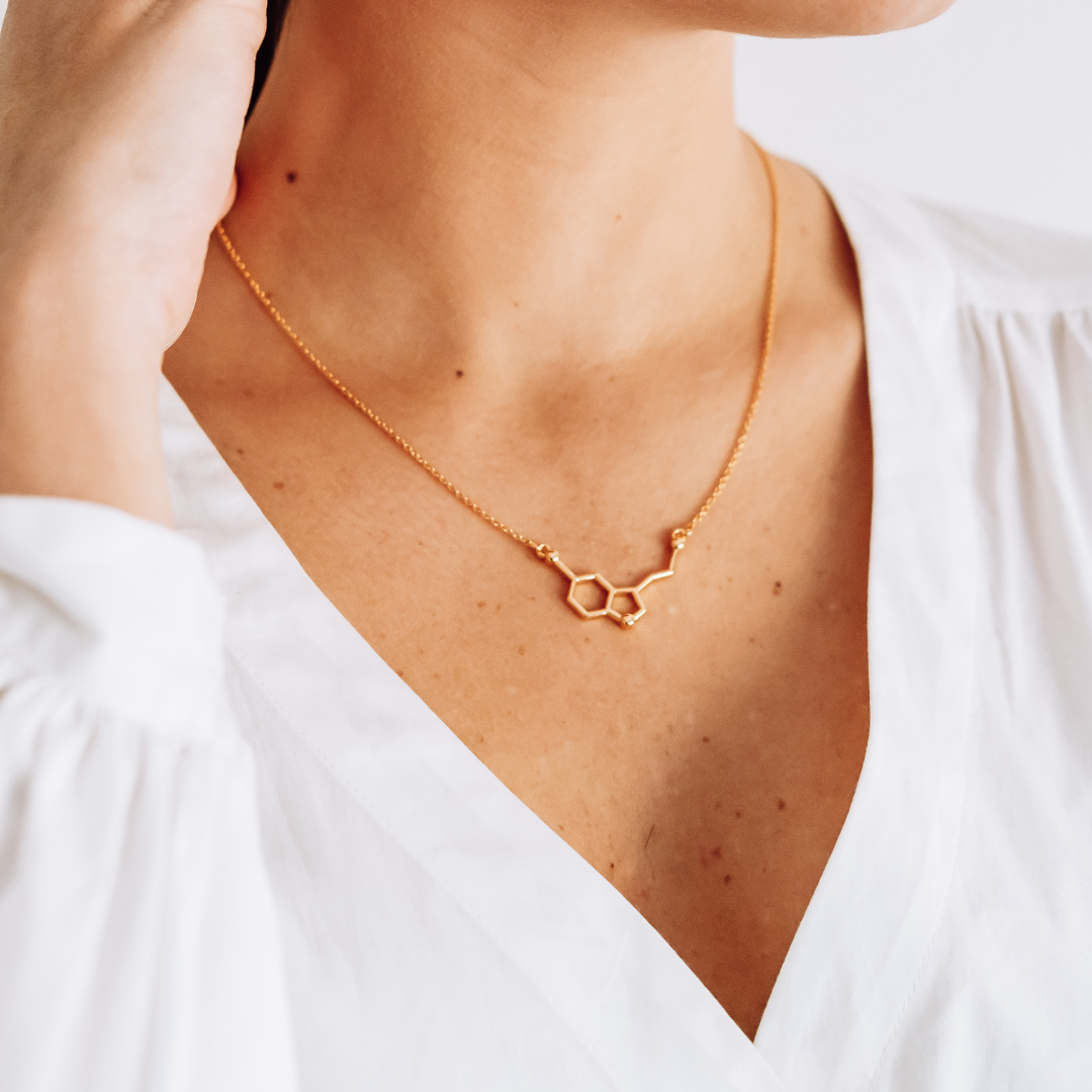 Model wearing serotonin molecule necklace in gold - chemistry inspired jewellery for science lovers | My Chemical Gift