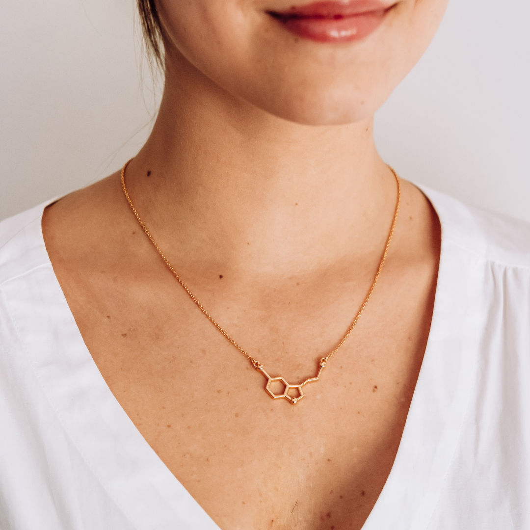 Model wearing serotonin molecule necklace in gold - chemistry inspired jewellery for science lovers | My Chemical Gift