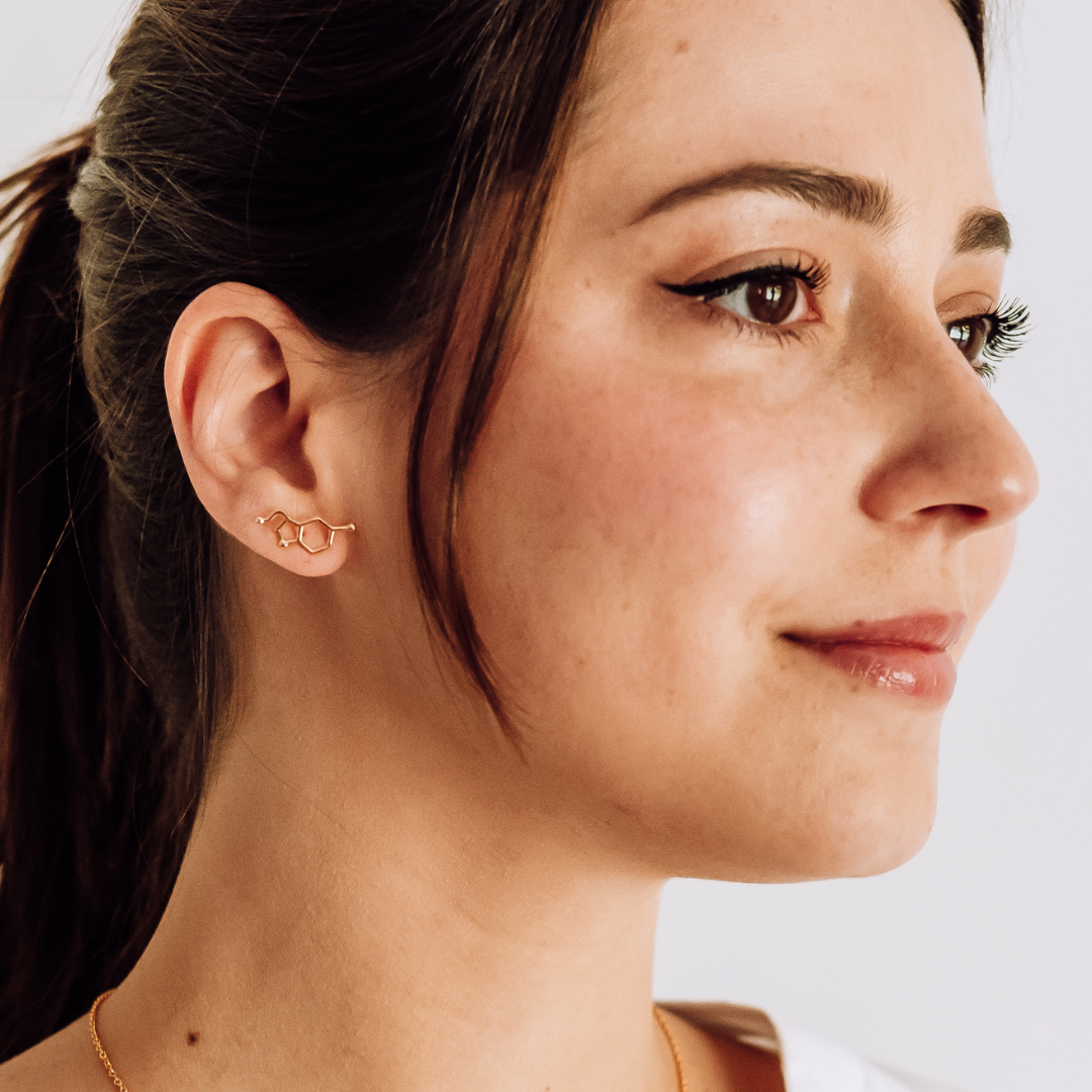 Model wearing serotonin molecule earrings in gold - chemistry inspired jewellery for science lovers | My Chemical Gift