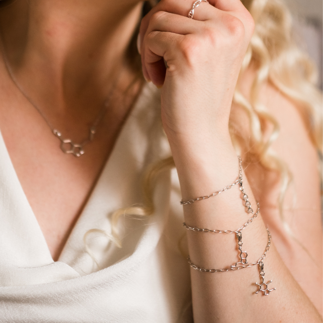 Model wearing caffeine molecule and serotonin molecule silver charm bracelet - chemistry inspired jewellery for science lovers | My Chemical Gift