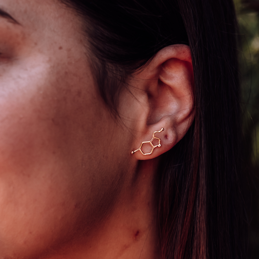 Model wearing serotonin molecule earrings in gold - chemistry inspired jewellery for science lovers | My Chemical Gift