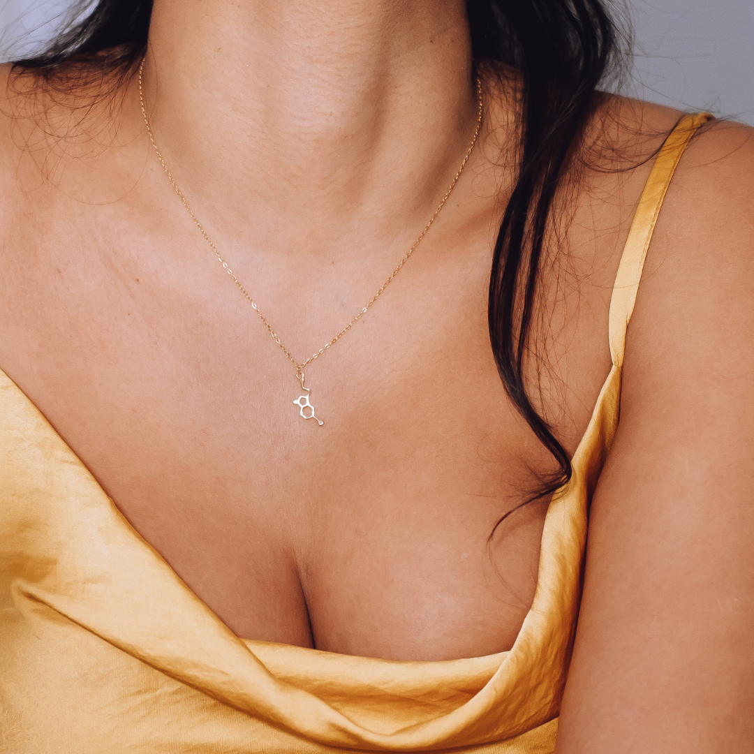 Model wearing serotonin molecule necklace in gold - chemistry inspired jewellery gift for science lovers | My Chemical Gift