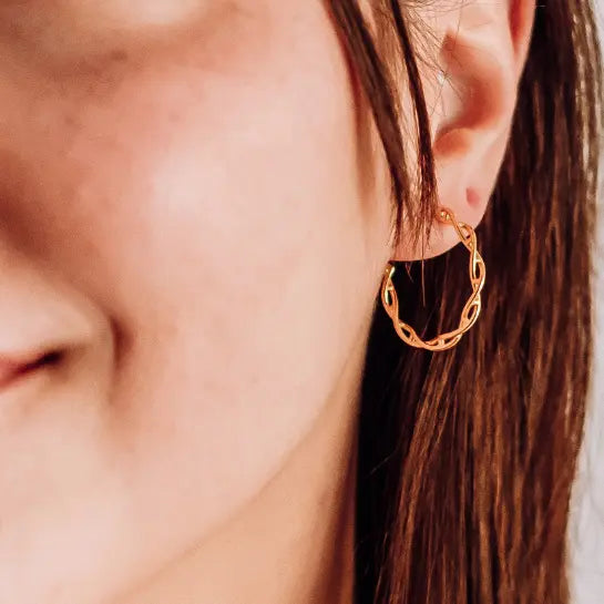Model wearing DNA double helix hoop earrings in gold - chemistry inspired jewellery for science lovers 