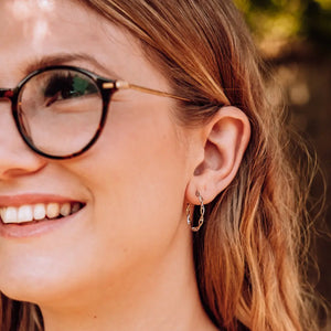 Model wearing DNA double helix hoop earrings in silver - chemistry inspired jewellery for science lovers 