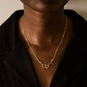 Model wearing serotonin molecule necklace in gold - chemistry inspired jewellery for science lovers 