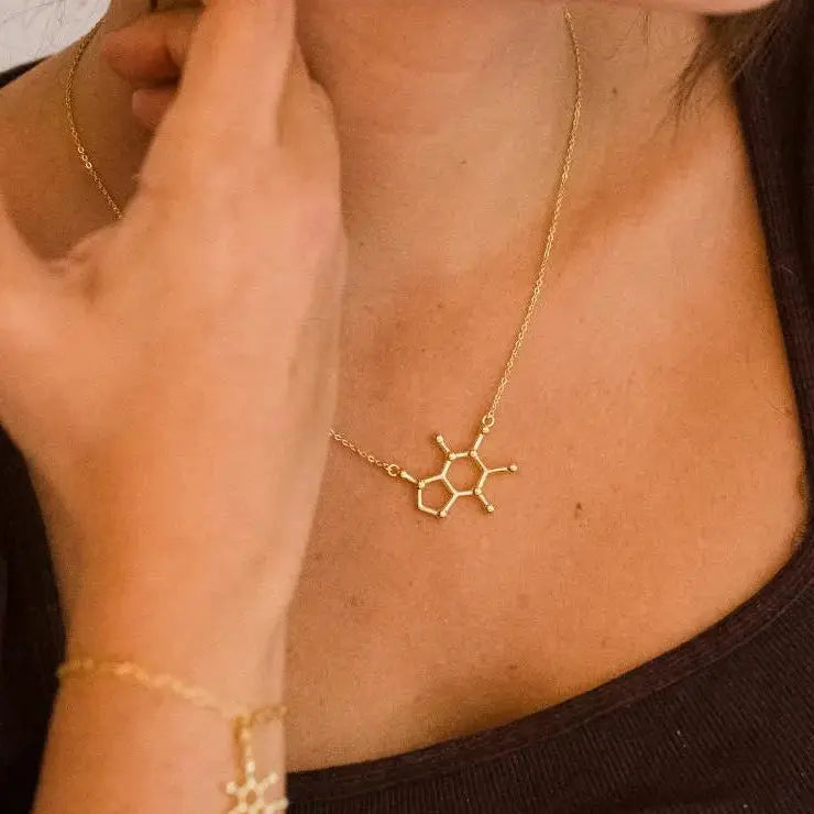 Model wearing caffeine molecule necklace in gold - science inspired jewellery gift for coffee lovers