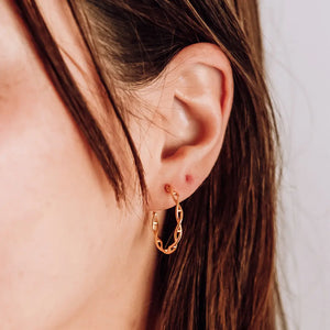 Model wearing DNA double helix hoop earrings in gold - chemistry inspired jewellery for science lovers 