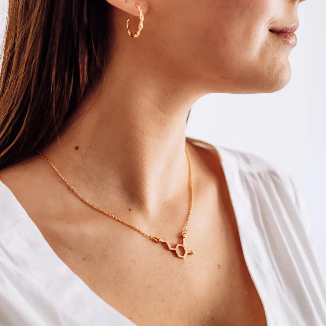 Model wearing dopamine molecule necklace in gold - chemistry inspired jewellery for science lovers 