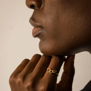 Model wearing serotonin molecule ring in gold - chemistry inspired jewellery for science lovers