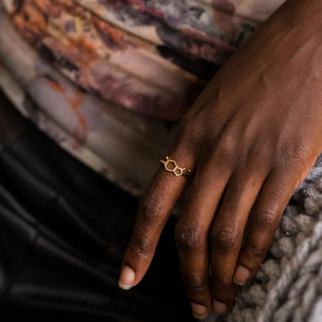 Model wearing serotonin molecule ring in gold - chemistry inspired jewellery for science lovers 