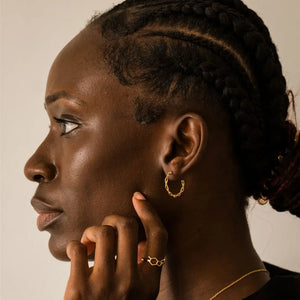 Model wearing DNA double helix hoop earrings in gold - chemistry inspired jewellery for science lovers 
