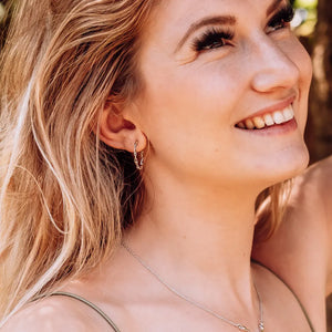 Model wearing DNA double helix hoop earrings in silver - chemistry inspired jewellery for science lovers 