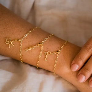 Model wearing caffeine molecule gold charm bracelet - chemistry inspired jewellery for coffee lovers 