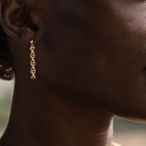 Model wearing DNA double helix earrings in gold - chemistry inspired jewellery gift for science lovers 