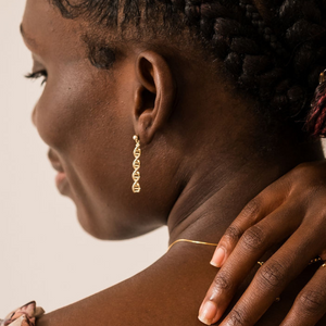 Model wearing gold helix earrings shaped like DNA double helix | Science-inspired jewellery gift for chemistry lovers
