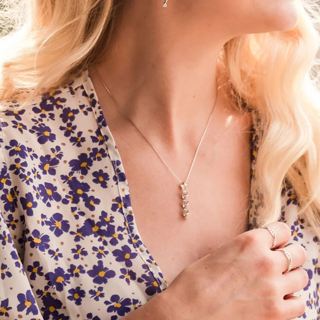 Model wearing DNA double helix necklace in silver - chemistry inspired jewellery gift for science lovers 