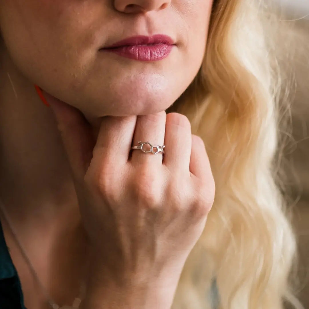 Model wearing serotonin molecule ring in silver - chemistry inspired jewellery for science lovers 