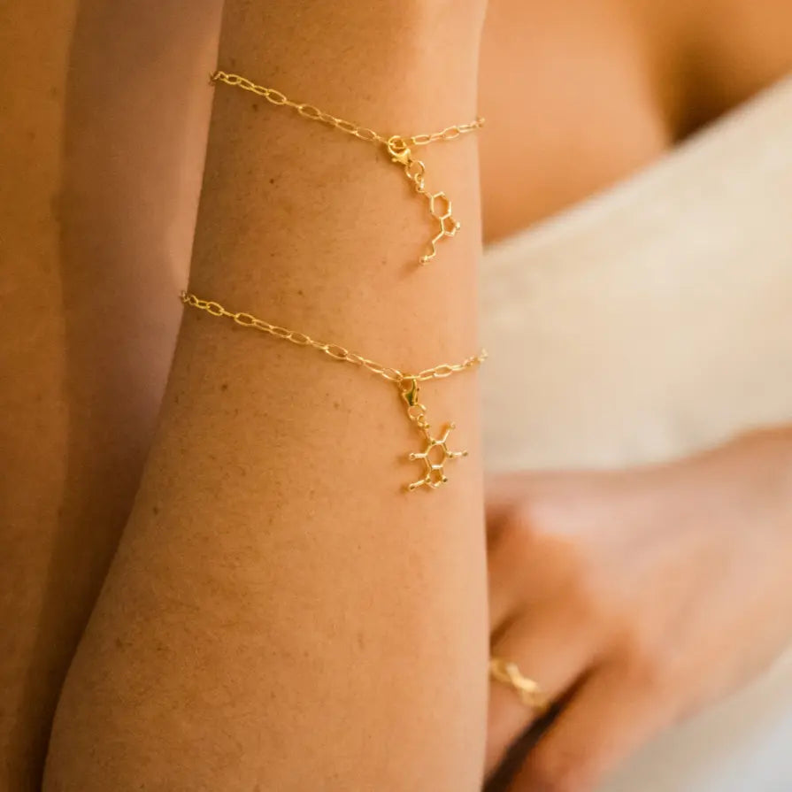 Model wearing caffeine molecule gold charm bracelet - chemistry inspired jewellery for coffee lovers 