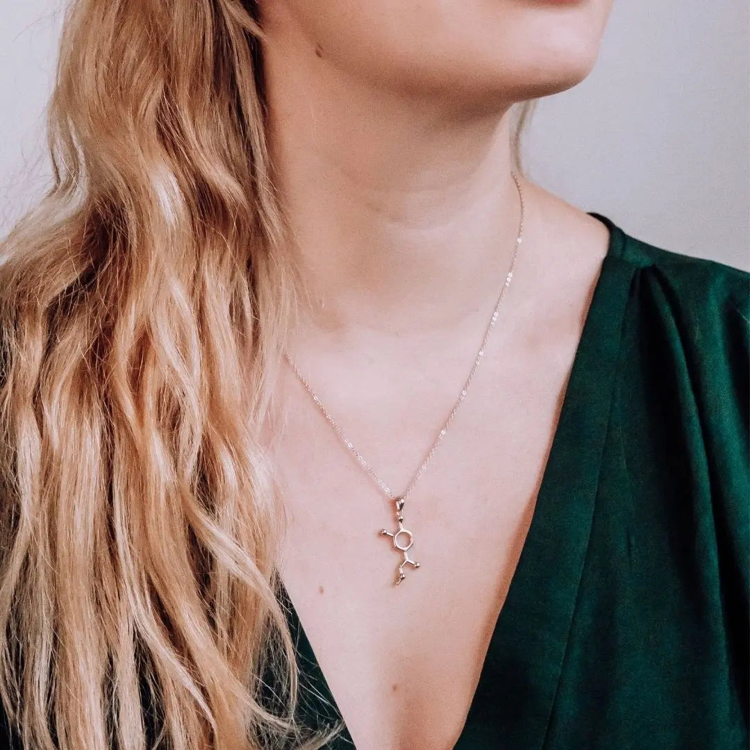 Model wearing adrenaline molecule necklace in silver - chemistry inspired jewellery gift for science lovers 