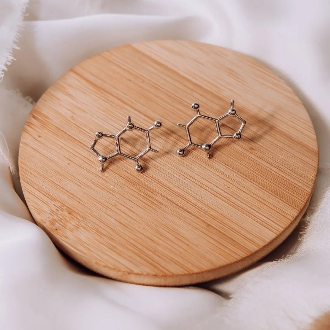 Caffeine molecule earrings in silver on a wooden background - chemistry inspired jewellery gift for coffee lovers 