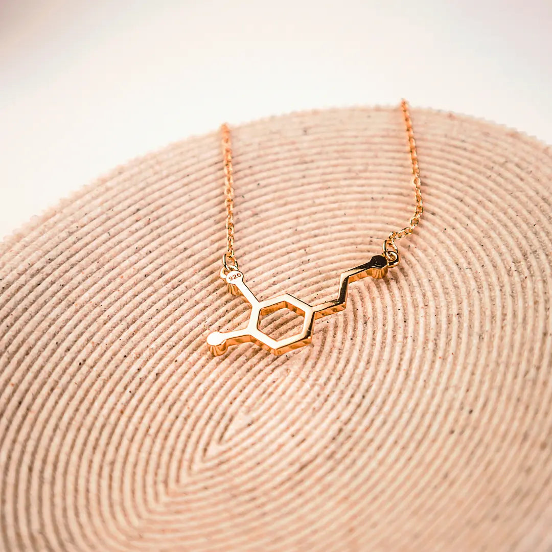 Dopamine molecule necklace in gold on a wooden background - chemistry inspired jewellery for science lovers 