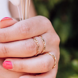 Model wearing DNA double helix ring in gold - chemistry inspired jewellery gift for science lovers 