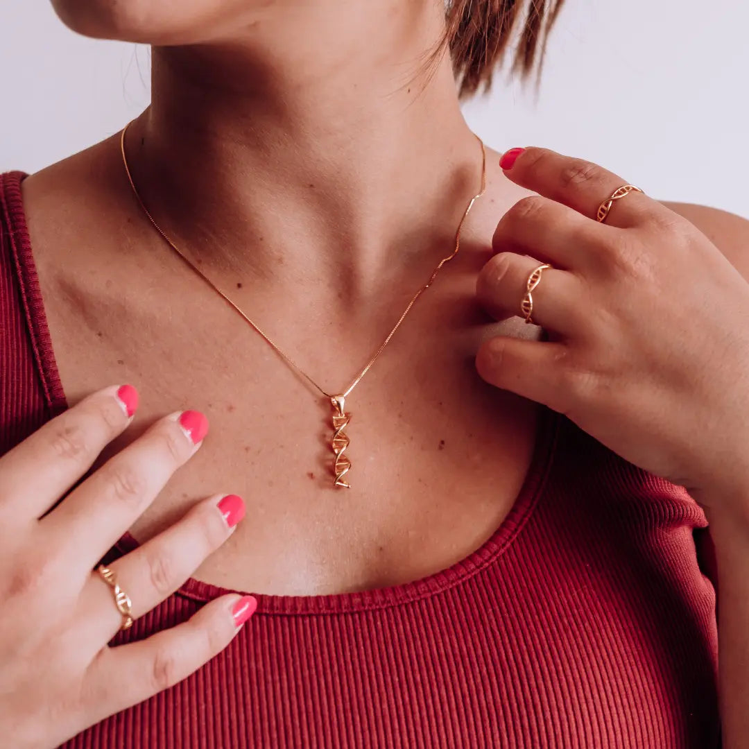 Model wearing DNA double helix necklace in gold - chemistry inspired jewellery gift for science lovers 