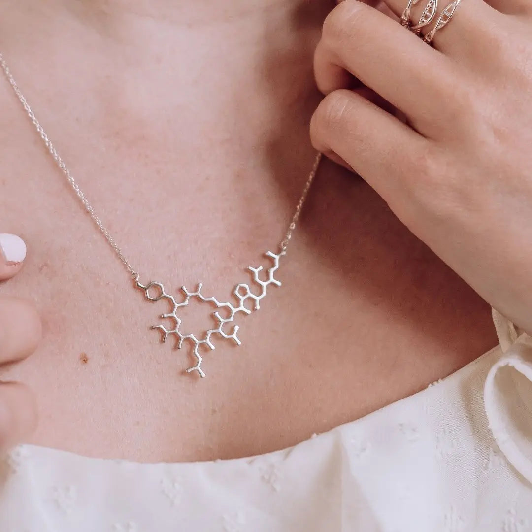 Model wearing oxytocin molecule necklace in silver - love hormone pendant 