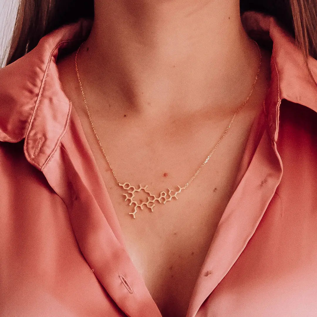 Model wearing oxytocin molecule necklace in gold - love hormone pendant