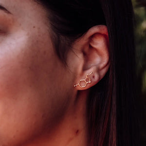 Model wearing serotonin molecule earrings in gold on a model - chemistry inspired jewellery for science lovers 