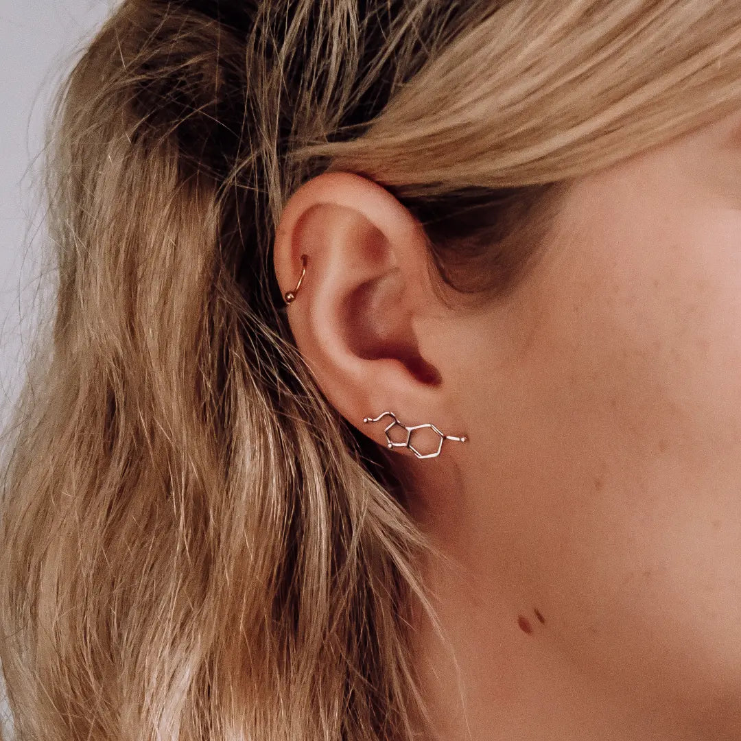 Model wearing serotonin molecule earrings in silver - chemistry inspired jewellery gift for science lovers 