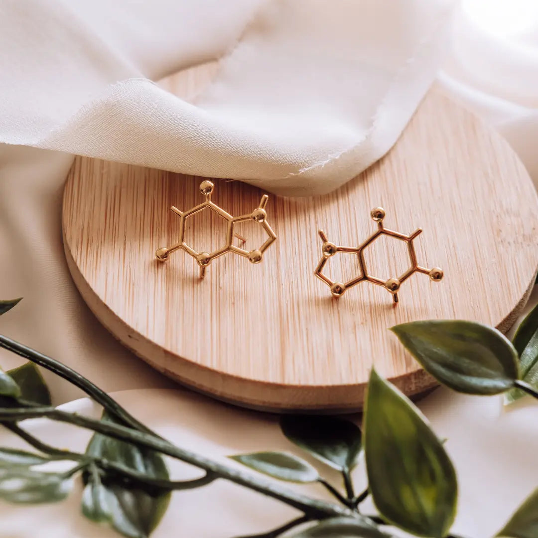 Caffeine molecule earrings in gold on a wooden background - science inspired jewellery gift for coffee lovers 