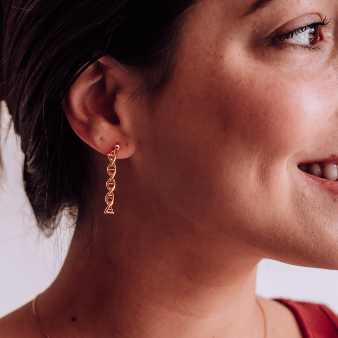 Model wearing DNA double helix earrings in gold - chemistry inspired jewellery gift for science lovers 