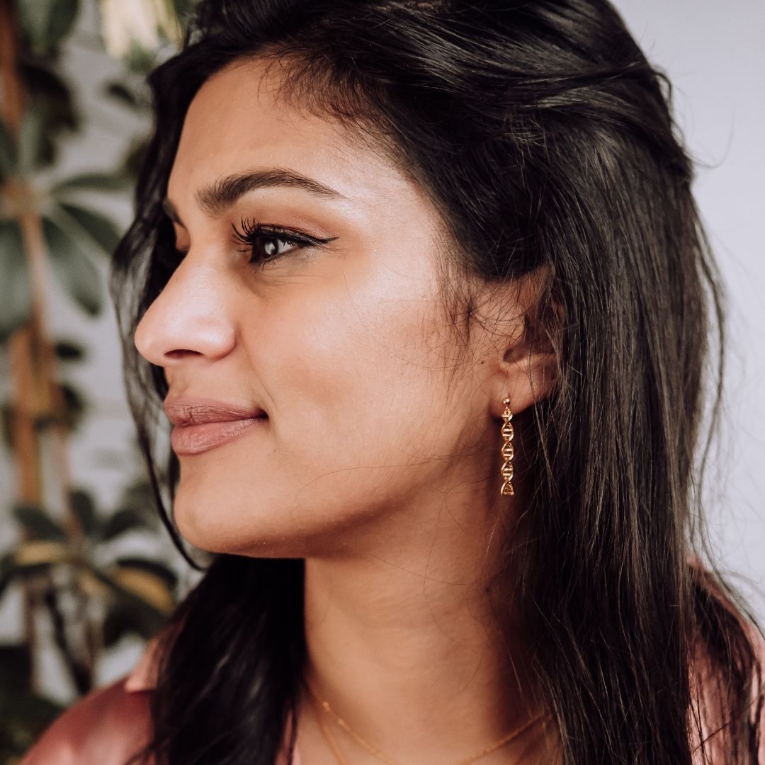 Model wearing DNA double helix earrings in gold - chemistry inspired jewellery gift for science lovers 