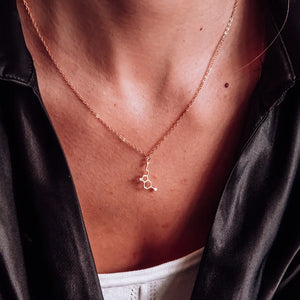 Model wearing serotonin molecule necklace in gold - chemistry inspired jewellery gift for science lovers 